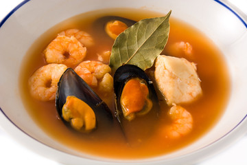 French bouillabaisse soup in white plate isolated on white background. Close up