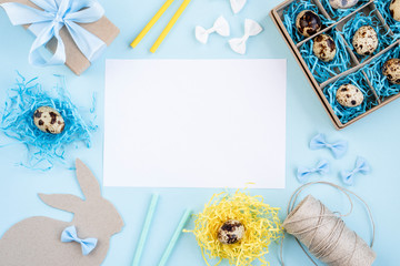 Easter eggs in a paper box and nests. Easter Bunny with a blue bow. Easter gift with a blue ribbon. Blank for a greeting card. Blue background creative.