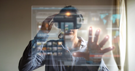 An young woman is using innovative technology vr glasses with augmented reality holograms. Concept...