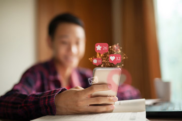 Happy Teenage of Asian man using a mobile phone to access social media as a tool of online marketing or learning