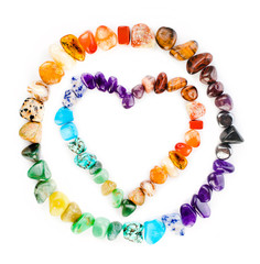 Heart made of colorful semiprecious gemstones isolated on a white background.