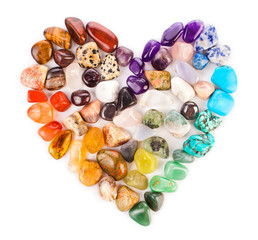 Heart made of colorful semiprecious gemstones isolated on a white background.