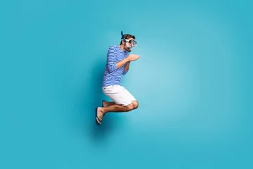 Fotobehang Full size profile photo of funky crazy guy tourist jump high swimming deep water mask tube diving wear striped sailor shirt vest shorts flip flops isolated blue color background © deagreez