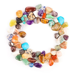 Circle made of colorful semiprecious gemstones isolated on a white background.