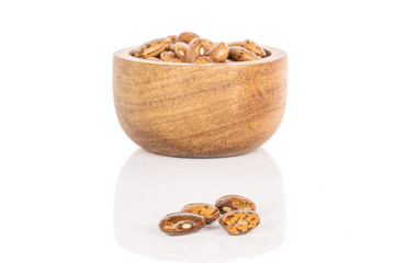Lot of whole uncooked mottled brown bean pinto in bamboo bowl isolated on white background