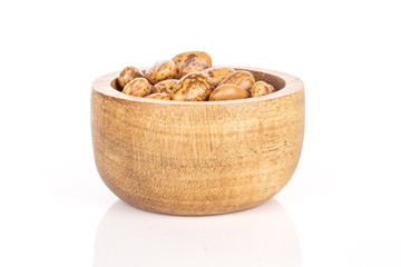 Lot of whole mottled brown bean pinto in bamboo bowl isolated on white background