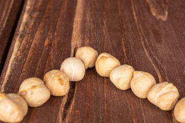 Group of ten whole fresh tan chickpea on brown wood