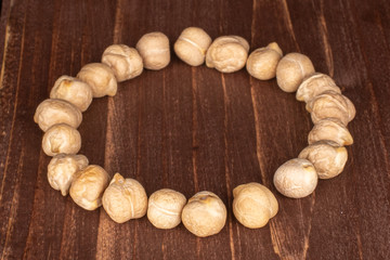 Lot of whole fresh tan chickpea circle on brown wood