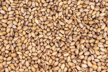 Closeup top view flatlay photography of many pistachios nuts. Organic food texture as photo background.