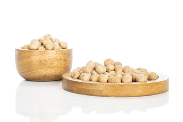 Lot of whole fresh tan chickpea in bamboo bowl on round bamboo coaster isolated on white background