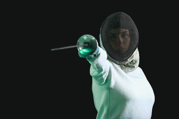 Young female fencer on dark background