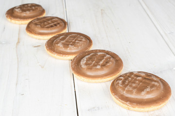 Group of five whole chocolate biscuit on white wood