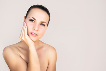 Young woman, beautiful female smiling on an isolated white background. Beauty concept: natural youth, body care, radiant facial skin. Copy space