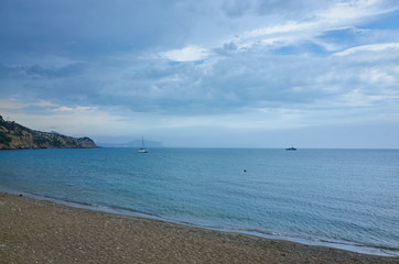 Fototapeta na wymiar Sea coast. Sandy beach overlooking the mountain range and the horizon. Thick clouds. Black Sea
