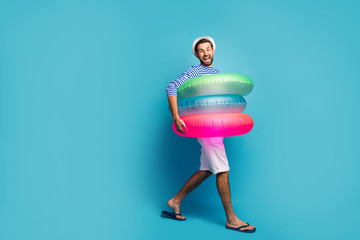 Full length profile photo of funky guy tourist walking seaside inside three colorful rubber...