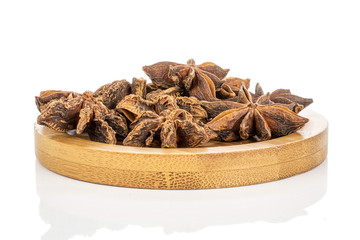 Lot of whole aromatic brown badian on round bamboo coaster isolated on white background