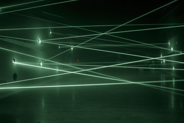 Green laser beams in a chaotic order from one wall to another.  Safety system