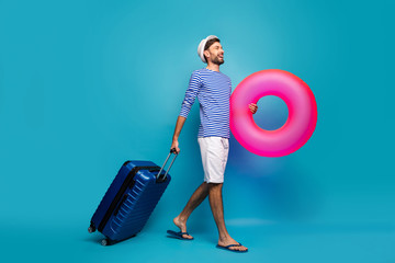 Full body profile photo of handsome guy traveler rolling case hold big pink lifebuoy want to see...