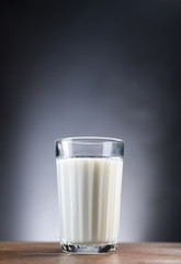 Glass faceted cup with milk stands on a wooden table 
