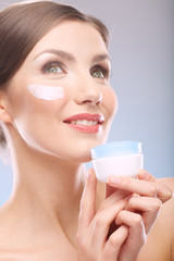 close up beauty portrait of smiling woman holding jar cream.