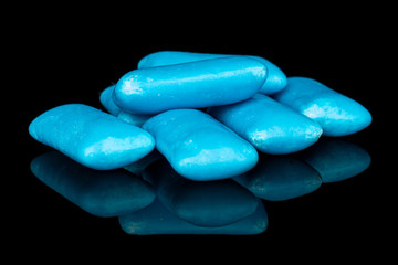 Lot of whole blue chewing gum stack isolated on black glass
