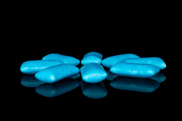 Group of eight whole blue chewing gum isolated on black glass