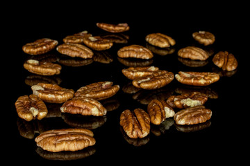 Lot of whole disordered tasty brown pecan half isolated on black glass