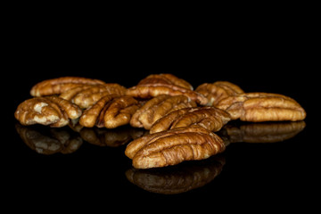 Lot of whole shelled tasty brown pecan half isolated on black glass
