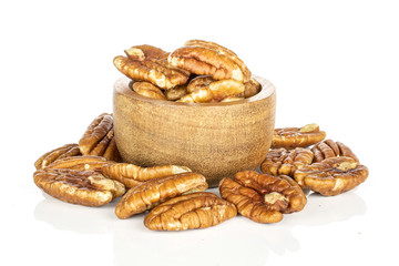 Lot of whole tasty brown pecan half in bamboo bowl isolated on white background