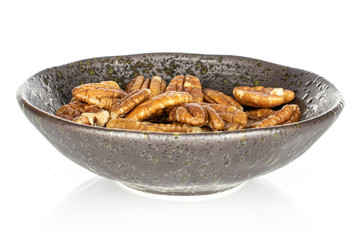 Lot of whole tasty brown pecan half in glazed bowl isolated on white background