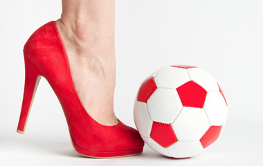 Woman leg in high heel shoe punch a soccer ball