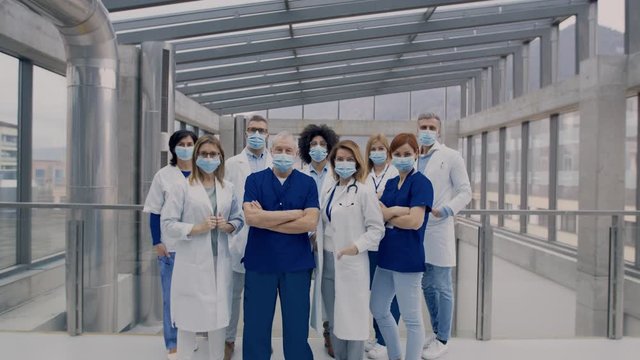 Doctors in masks standing with arms crossed
