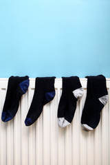 Socks drying on a radiator on a rainy day with space for copy