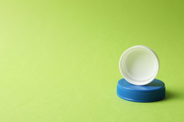 Bottle caps on green background, close up and space for text