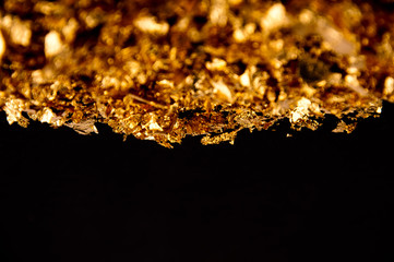 Real 24k gold flakes on black background