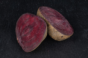 Group of two halves of raw sweet beetroot on grey stone