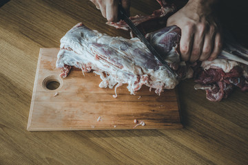 Сutting lamb meat on a wooden board