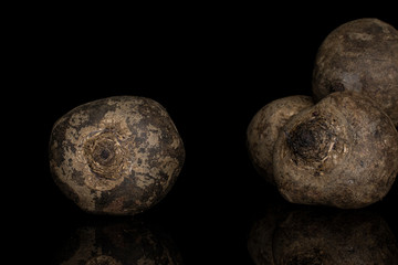 Group of four whole raw sweet beetroot isolated on black glass