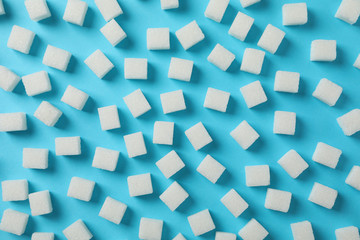 Sugar cubes on blue background, top view
