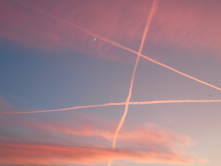 Genova, Italy - 01/25/2020: An amazing caption of the sunset in winter days over the city of Genova with beautiful red sky, some amazing clouds and small moonlight in the background.