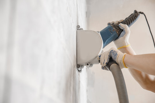 Builder Worker Cutting Electrical Chase In Concrete Wall With Circulation Saw Drill Diamond Crown