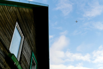 Airplane flying above old house