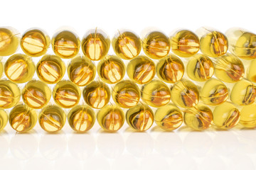 Lot of whole golden fish oil isolated on white background