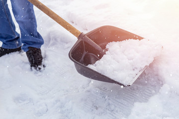 City service cleaning snow winter with shovel after snowstorm yard sunlight