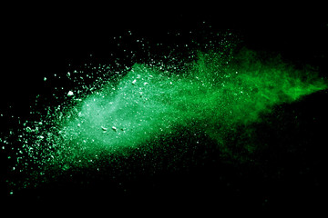 Green powder explosion on black background.