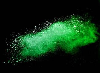 Green powder explosion on black background.