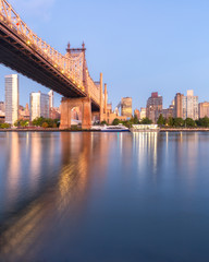 Naklejka premium Queensboro Bridge and Roosevelt Island at sunrise from East river with long exposure