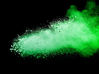 Green powder explosion on black background.