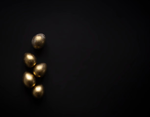 on a black background five beautiful golden easter eggs copy space
