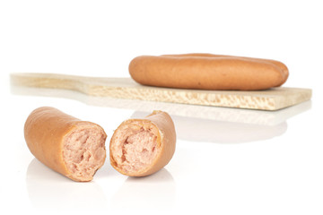 Group of two whole two halves of pork frankfurt sausage on wooden cutting board isolated on white background